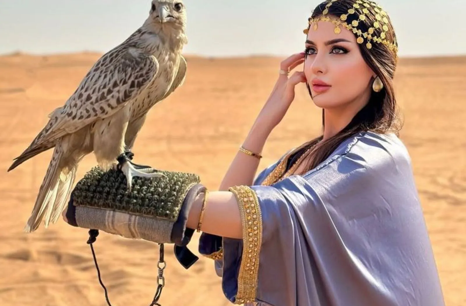 Tourist holding a falcon during a desert safari in Dubai