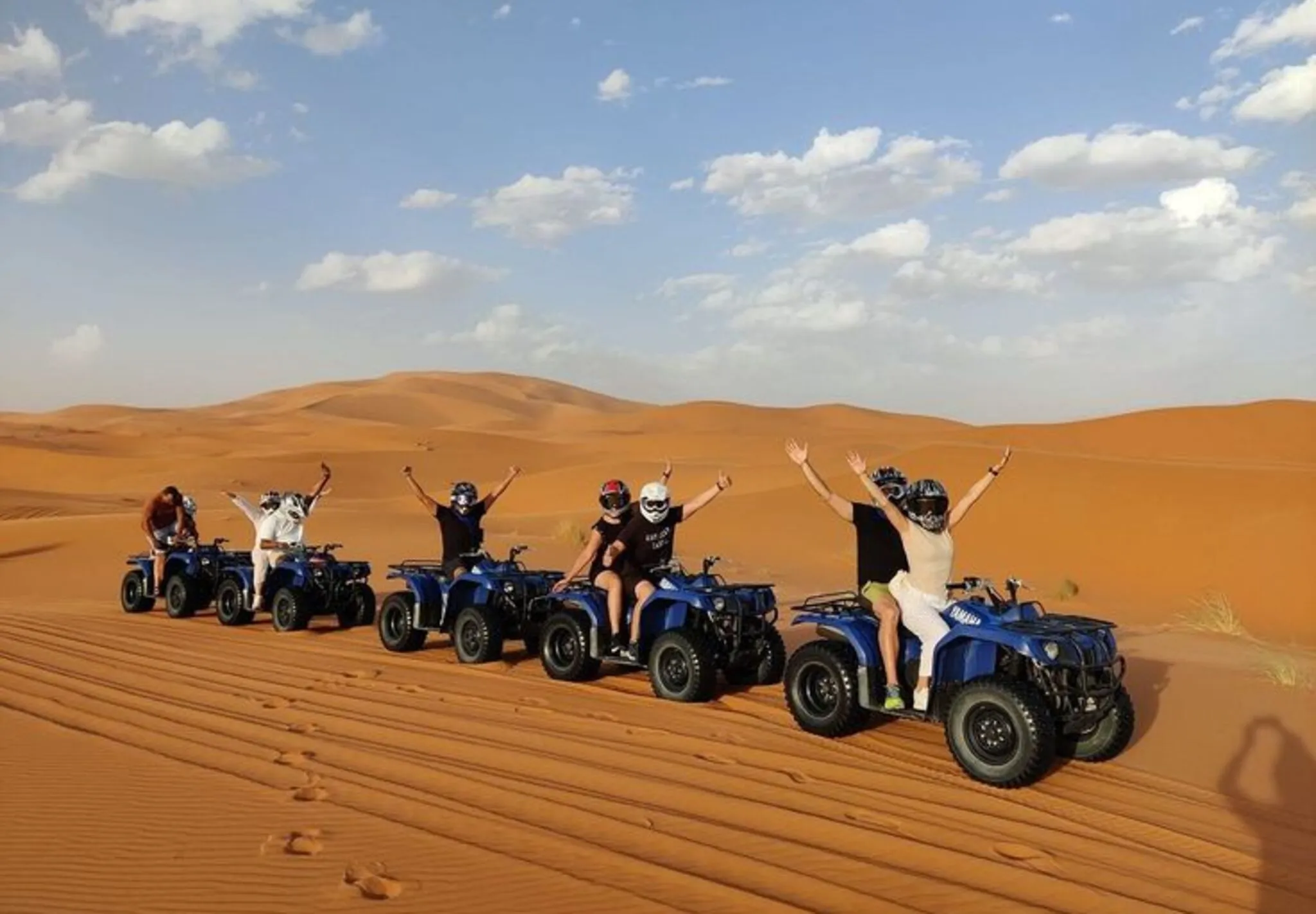 Group of guests sitting on quad bikes during a morning desert safari in Dubai