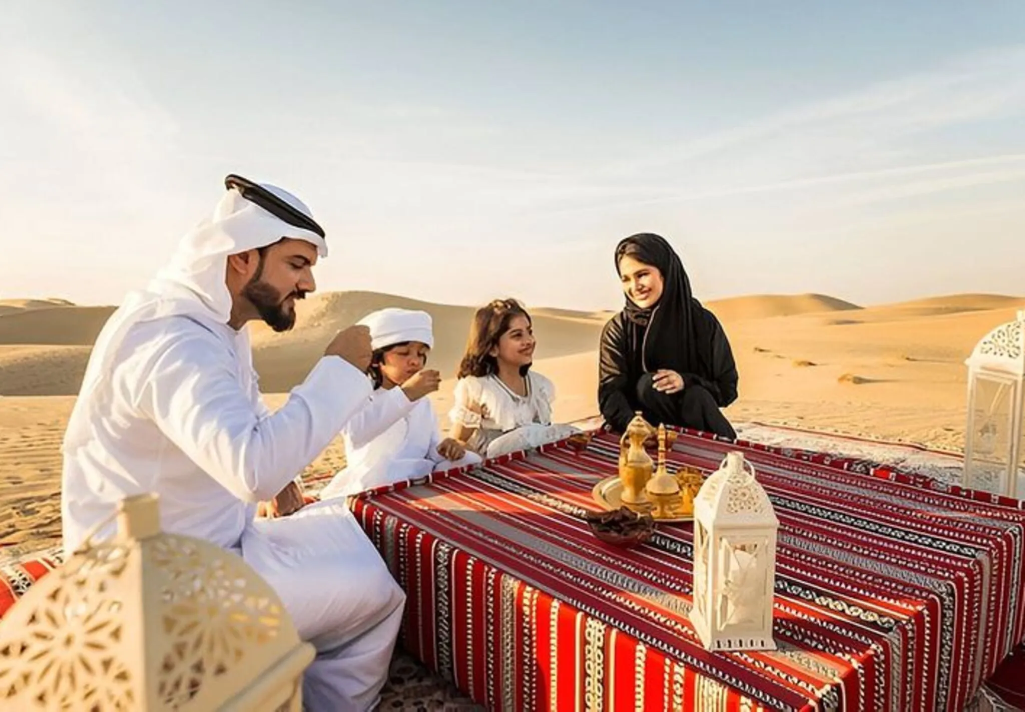 Family enjoying authentic Arabic coffee and traditional Emirati hospitality during a morning desert safari in Dubai